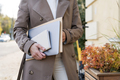Confident business woman with folder and laptop in hands in urban street - PhotoDune Item for Sale