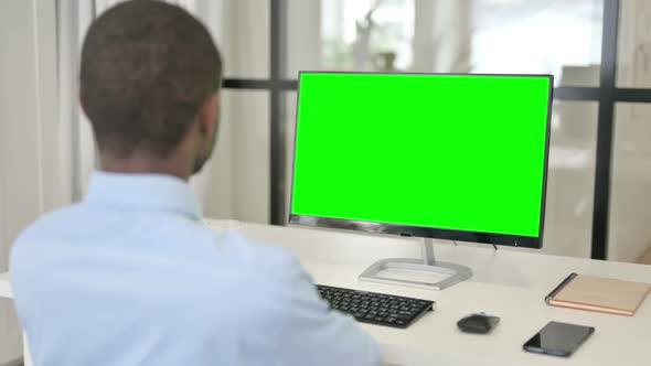 Businessman Looking at Desktop with Green Chroma Key Screen