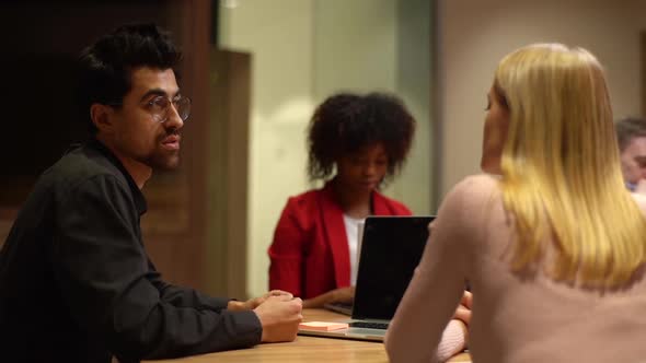 Tracking Shot of Serious Male Manager Sharing Knowledge with New Female Colleague Explaining Problem