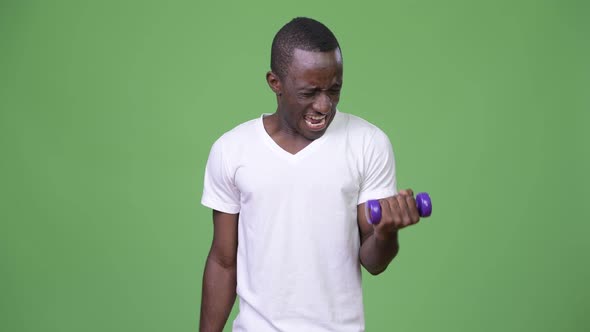 Young African Man Exercising with Dumbbells