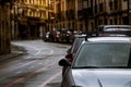 Row of cars parked along the street and old buildings in Europe city. Many cars parked on road  - PhotoDune Item for Sale