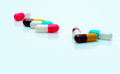 Multi-color antibiotic capsule pills spread on white background. Antibiotic drug resistance. - PhotoDune Item for Sale