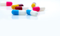 Selective focus on blue-white antibiotic capsule pills on white background. Prescription drugs. - PhotoDune Item for Sale