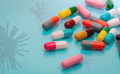 Antiviral capsule pills with virus on blue background. Drug development and new drug research - PhotoDune Item for Sale