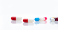 Red-white antibiotic capsule pill on blur multi-colored capsules background. Antibiotic drug - PhotoDune Item for Sale
