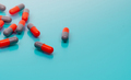 Orange and gray capsule pills on blue background. Pharmaceutical industry. Prescription drugs. - PhotoDune Item for Sale