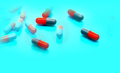 Selective focus on gray-orange antibiotic capsule pills on blue background. Pharmaceutical industry. - PhotoDune Item for Sale