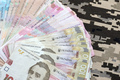 Ukrainian hryvnya bills on fabric with texture of Ukrainian military pixeled camouflage - PhotoDune Item for Sale