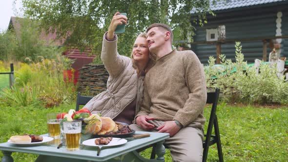 A Young Couple Spends the Summer in Country in Self-isolation, Take a Selfie on Smartphone, the Wife