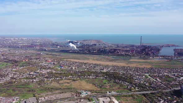 Metallurgical plant on the seashore. Environmental pollution.