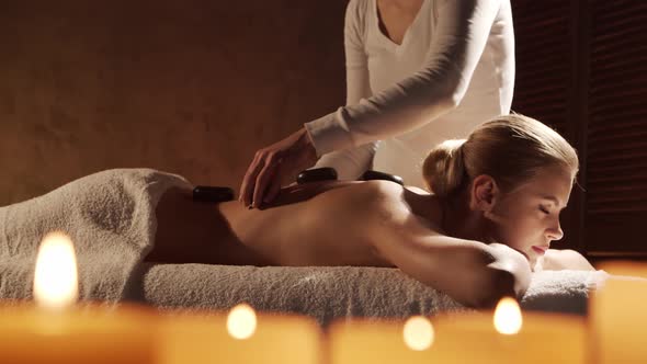 Young, healthy and beautiful woman gets massage therapy in the spa salon.