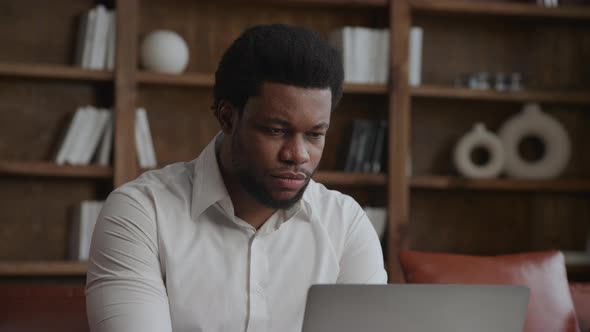 Closeup of an Adult Businessman Working on a Laptop in His Office