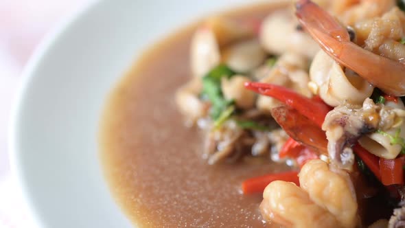 Squid and shrimp fried basil on a white plate