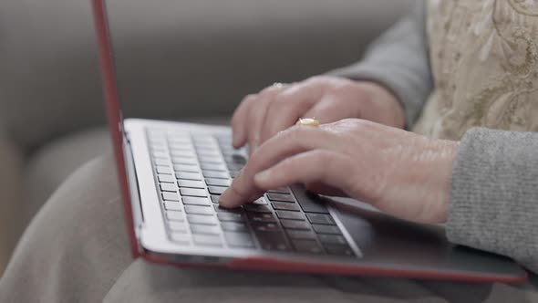 Closeup Senior Female Hands Typing on Laptop Keyboard