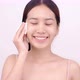Happy Asian girl using cotton pad applying facial wipe on her face, removing makeup. - VideoHive Item for Sale