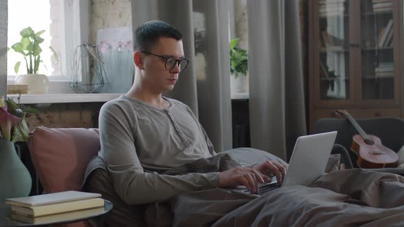 Freelancer Working On Laptop From Bed