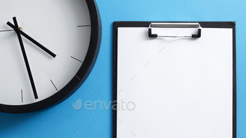 Overhead Flat Lay Business Shot Of Clipboard With Blank Page Or Form And Clock