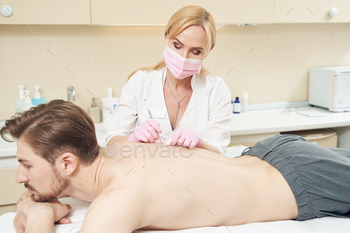 autician removing dirt and dead skin cells from pores with uno spoon