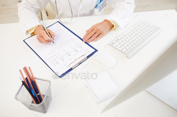 with computer and writing down symptoms of patient into medical card