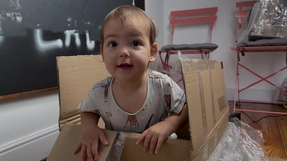 Big Large Cardboard Box Package Stands on Floor in Interior of Living Room Unexpectedly Happy Little