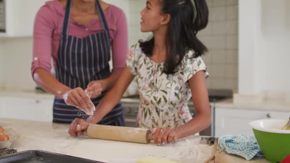 African american mother and daughter baking together in the kitchen at home