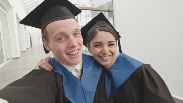 Two Joyful Diverse Graduates Making Selfie