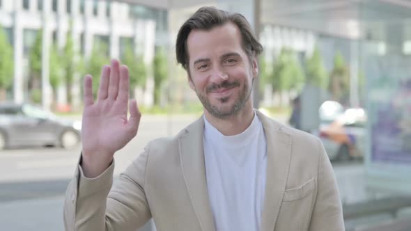 Welcoming Young Man Waving Hand for Hello Outdoor