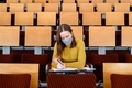 Woman student sitting in face mask - PhotoDune Item for Sale