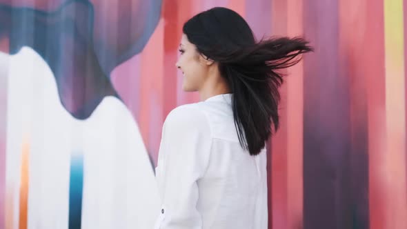 Attractive Girl of European Appearance Walks Down the Street Smiling