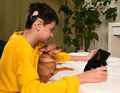 deaf boy with cochlear implant playing computer game on playstation and watching cartoon with dog - PhotoDune Item for Sale