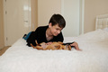 teenager playing with dog on bed - PhotoDune Item for Sale