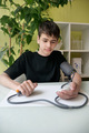 teenage boy measures his blood pressure at the table in the kitchen - PhotoDune Item for Sale