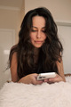 young brunette woman with long hair writes sms in mobile phone - PhotoDune Item for Sale