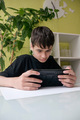 deaf teenager with a cochlear implant plays computer games on a tablet - PhotoDune Item for Sale