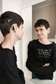 reflection in the mirror of a deaf teenage boy with a cochlear implant - PhotoDune Item for Sale