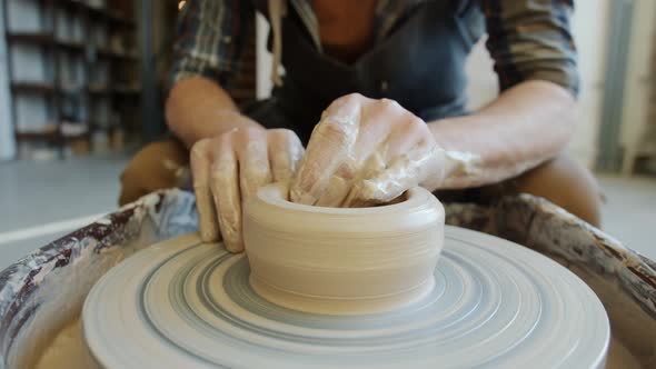 Close-up of Male Potter's Hands Manufacturing Ceramic Bowl From Clay Using Throwing Wheel