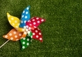 Colorful pinwheel toy on green grass background. - PhotoDune Item for Sale