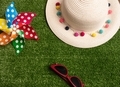 Colorful pinwheel, white hat and sunglasses on green grass - PhotoDune Item for Sale