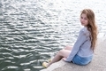 young woman with long hair sit on the edge of the pier on the sea promenade - PhotoDune Item for Sale