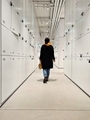 a young woman walks inside a modern building along a long corridor with white cabinets - PhotoDune Item for Sale