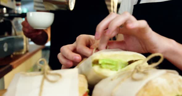 Waitress wrapping sandwich with a wax paper