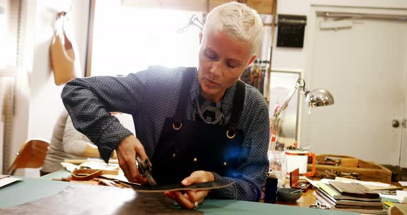 Craftswoman punching hole from leather punch machine