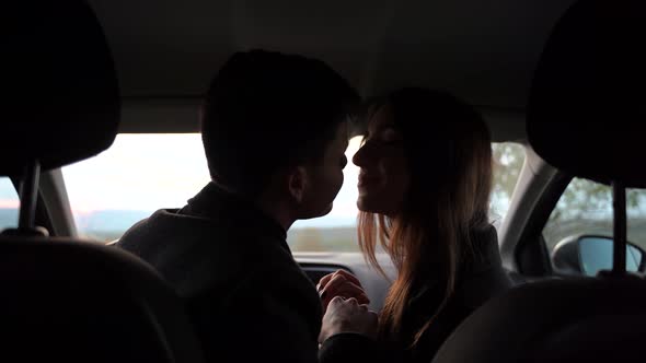 Boy and Girl Holding Hands and Looking at Each Other While Sitting Inside