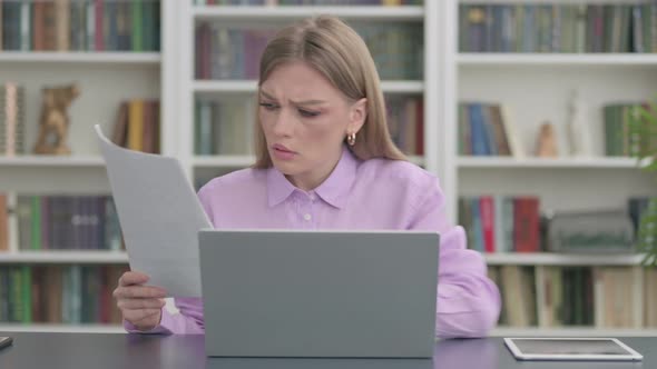 Woman with Laptop Having Loss While Reading Documents