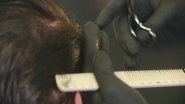 Barber Cutting Client's Hair with a Scissors