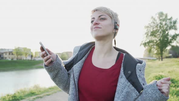 Young woman listening to music with mobile phone