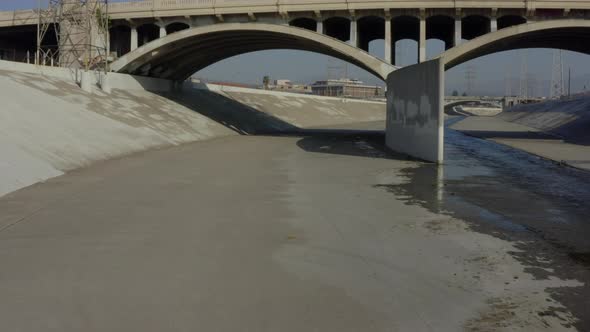 AERIAL: Under LA River Bridge, Los Angeles, California, Daylight 