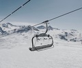 An empty ski lift chair in front of a majestic mountain view on a sunny day in the french alps - PhotoDune Item for Sale
