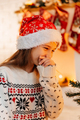 Portrait of a cheerful girl in a red Santa hat and a Christmas sweater - PhotoDune Item for Sale