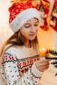 Portrait of a cheerful girl in a red Santa hat and a Christmas sweater - PhotoDune Item for Sale